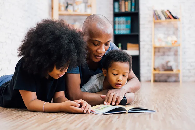 parents reading a book to their child