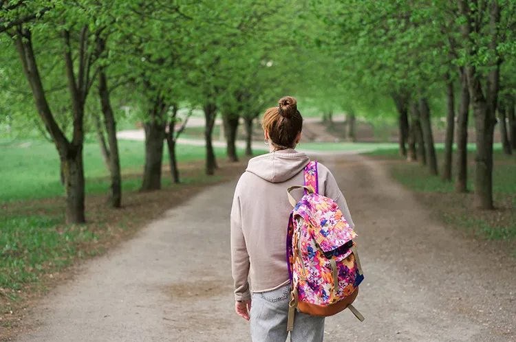 girl walking with a backpack on