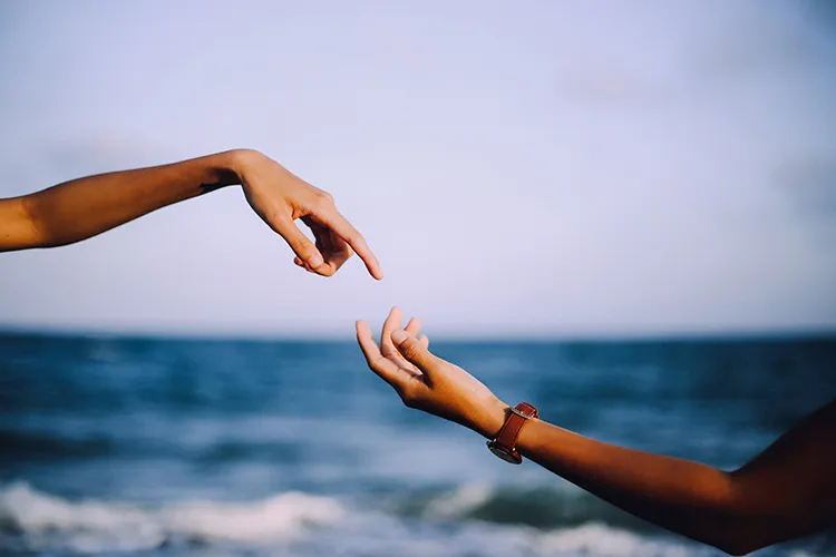 Two hands reach for each other