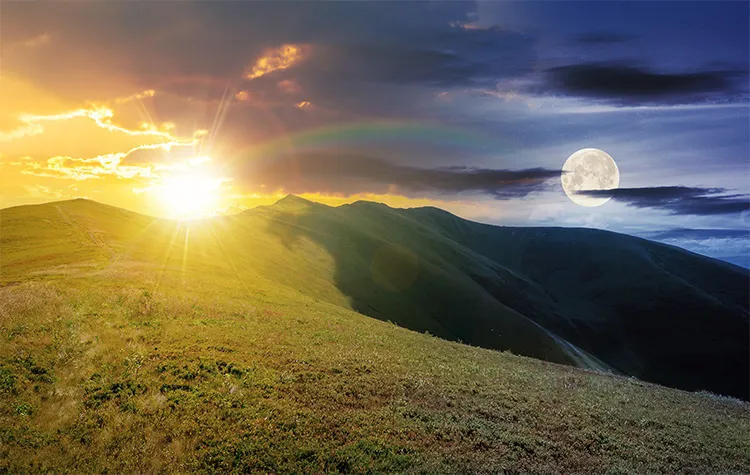 sun and moon over mountain range