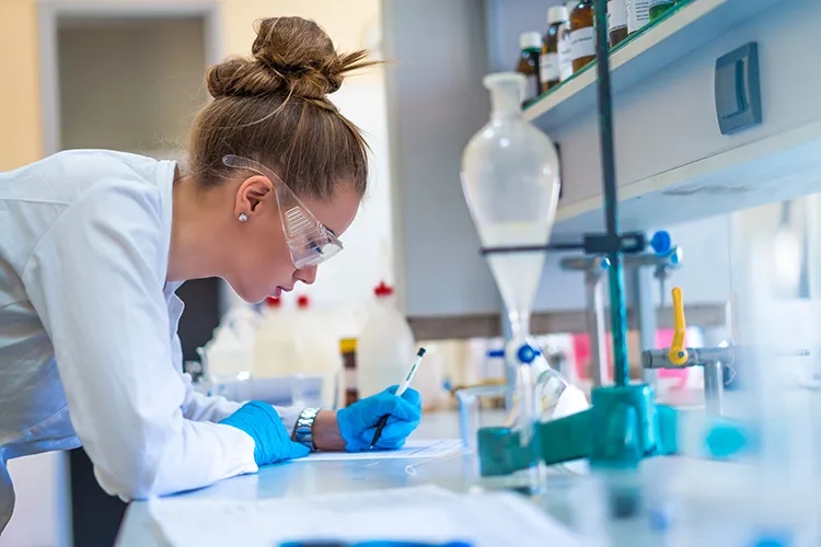 female student looking at a microscope in a lab
