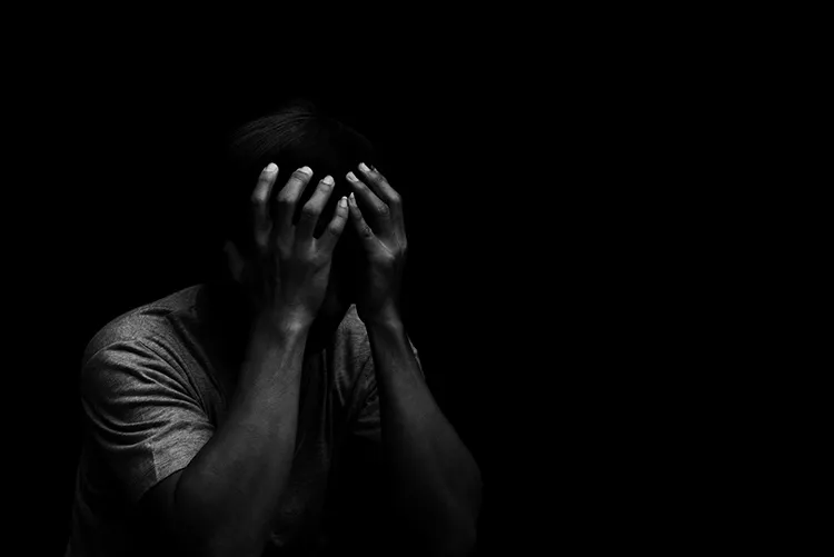 black and white photo of a man with his head in his hands