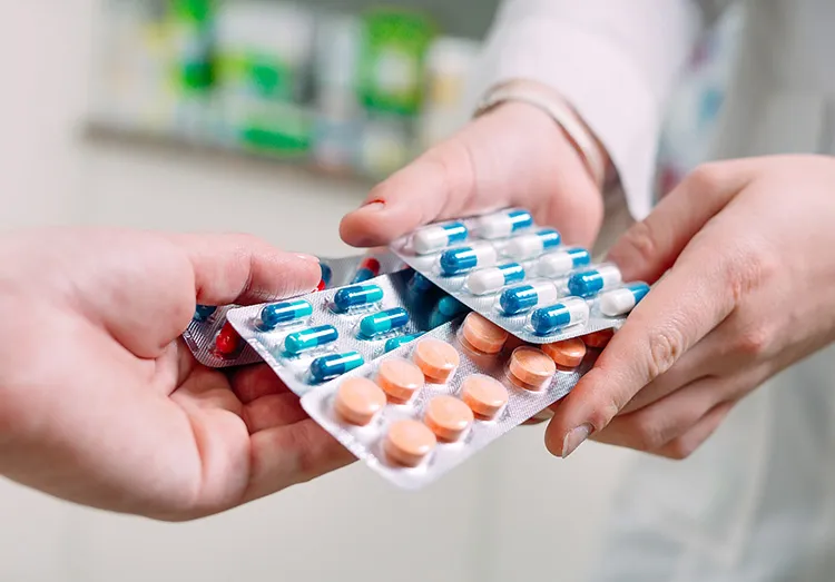 close up of hands exchanging packets of pills