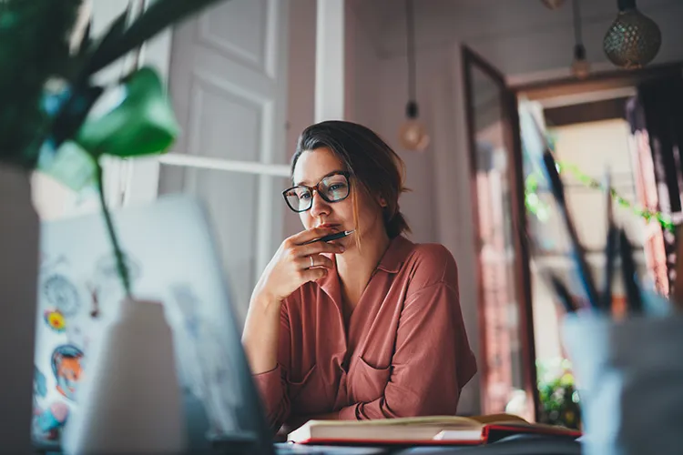 young businesswoman thinking about something while looking at her computer screen