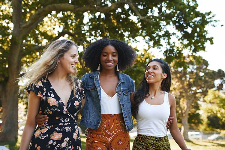 group of multiracial female friends walk together