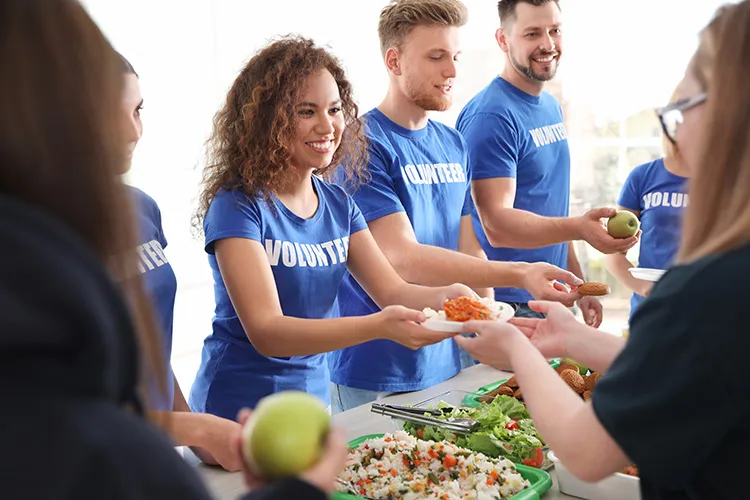 a group of volunteers serving food to people