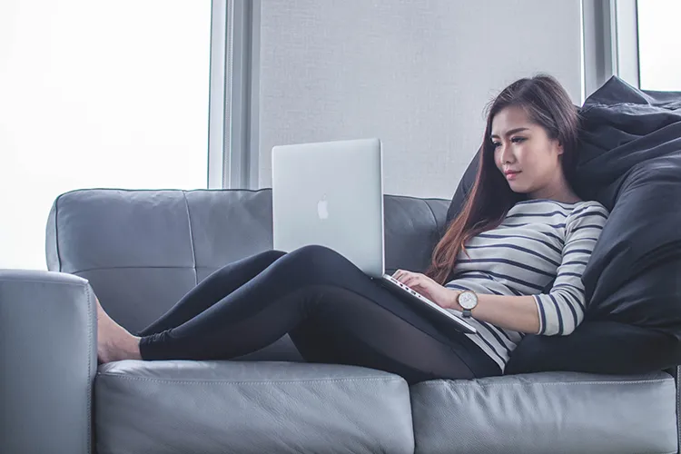 Woman writing on sofa